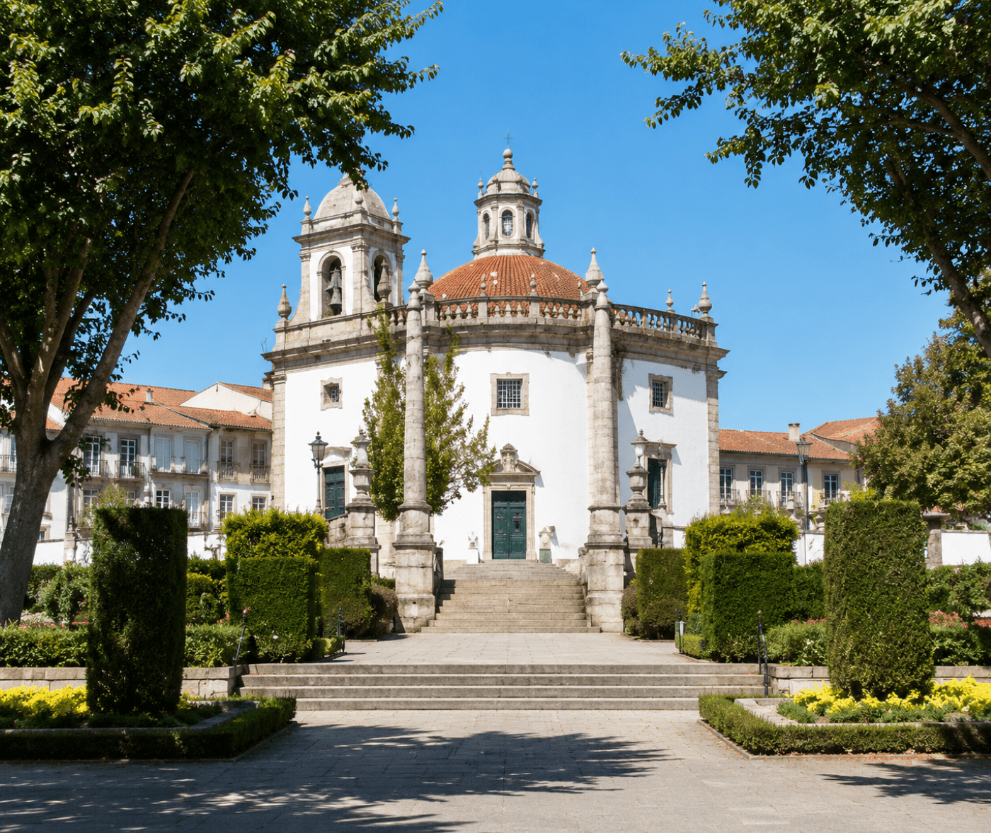 Igreja do Senhor da Cruz in Barcelos, Portugal, with its white Baroque façade, bell tower and gardens under a clear blue sky