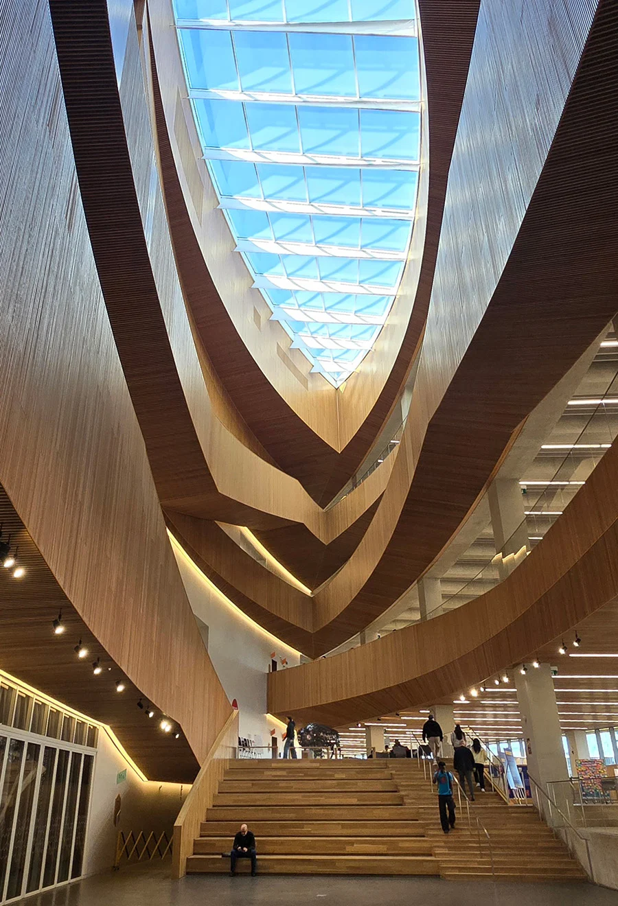 Sweeping wood-lined interior and skylight inside Calgary Central Library