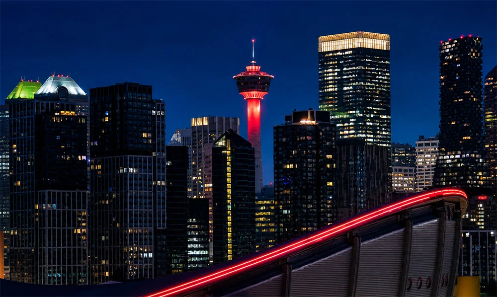 Calgary skyline at night with the illuminated Calgary Tower and Saddledome in downtown Calgary